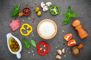Ev yapımı pizza otlar düz için malzemeler karanlık üzerinde yatıyordu 