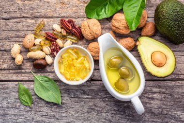 Omega 3 ve doymamış yağ seçimi gıda kaynakları. Superfood yüksek e vitamini ve sağlıklı gıda için diyet lifi. Badem, ceviz, fındık, ceviz, zeytin yağı, balık yağı ve somon ahşap arka plan üzerinde.