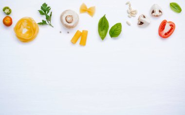 Çeşitli sebze ve yemek makarna menüsü fesleğen, domates, sarımsak, sızma zeytinyağı, kopya alanı Beyaz ahşap zemin üzerine maydanoz ve champignon kurulum için malzemeler.