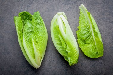 Gıda taze çünkü marul düz arka plan ve salata konseptiyle taş koyu arka plan üzerinde yatıyordu.
