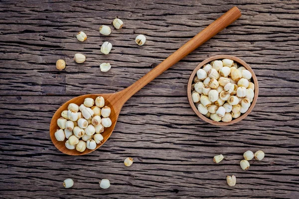 Composition of raw lotus seeds .The asian popular seed for food ,desserts and herbal medicine in wooden spoon on brown background.