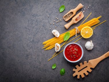 İtalyan gıda ve menü kavramı. Spagetti malzemeler fesleğen, domates, sarımsak biber ve champignon koyu arka plan düz lay ve kopya alanı.