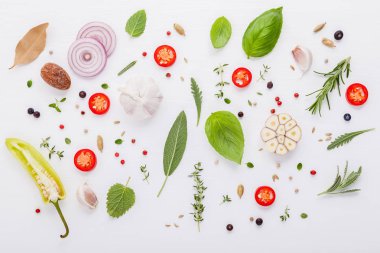 İngrediens nane, fesleğen, biberiye, kekik, adaçayı, biber defne yaprağı ve limon kekik düz lay ile beyaz ahşap zemin üzerinde yemek pişirmek için çeşitli taze otlar .