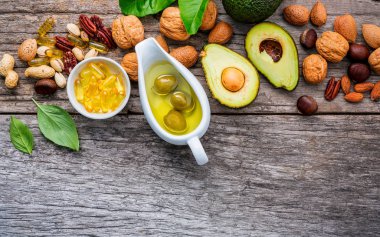 Omega 3 ve doymamış yağ seçimi gıda kaynakları. Superfood yüksek e vitamini ve sağlıklı gıda için diyet lifi. Badem, ceviz, fındık, ceviz, zeytin yağı, balık yağı ve somon ahşap arka plan üzerinde.