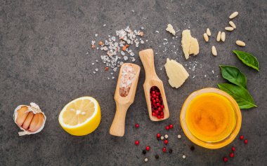 Ev yapımı pesto sos fesleğen, parmesan peyniri, sarımsak, zeytinyağı, limon, çam fıstığı, biber Mısır ve Himalaya tuz düz lay ile karanlık taş zemin üzerine ve kopya alanı için malzemeler.