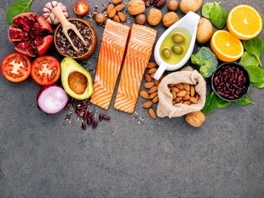 Sağlıklı yiyecek seçimi için gerekli malzemeler koyu arka planda. Doymamış yağların dengeli bileşenleri ve kalp ve kan damarları için lif..