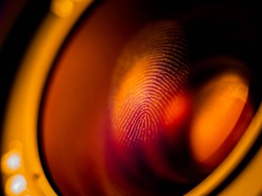 Kırmızı ışıkta mercekte parmak izi makrosu, yüzeysel alan derinliği. Biyometrik ve güvenlik kavramı.