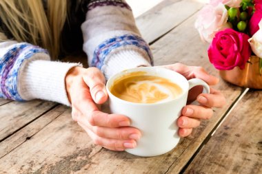 Ellerinde bir fincan kahve.