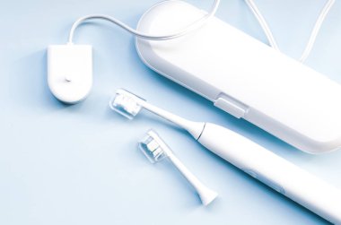 Mavi arkaplanda elektrikli diş fırçası.