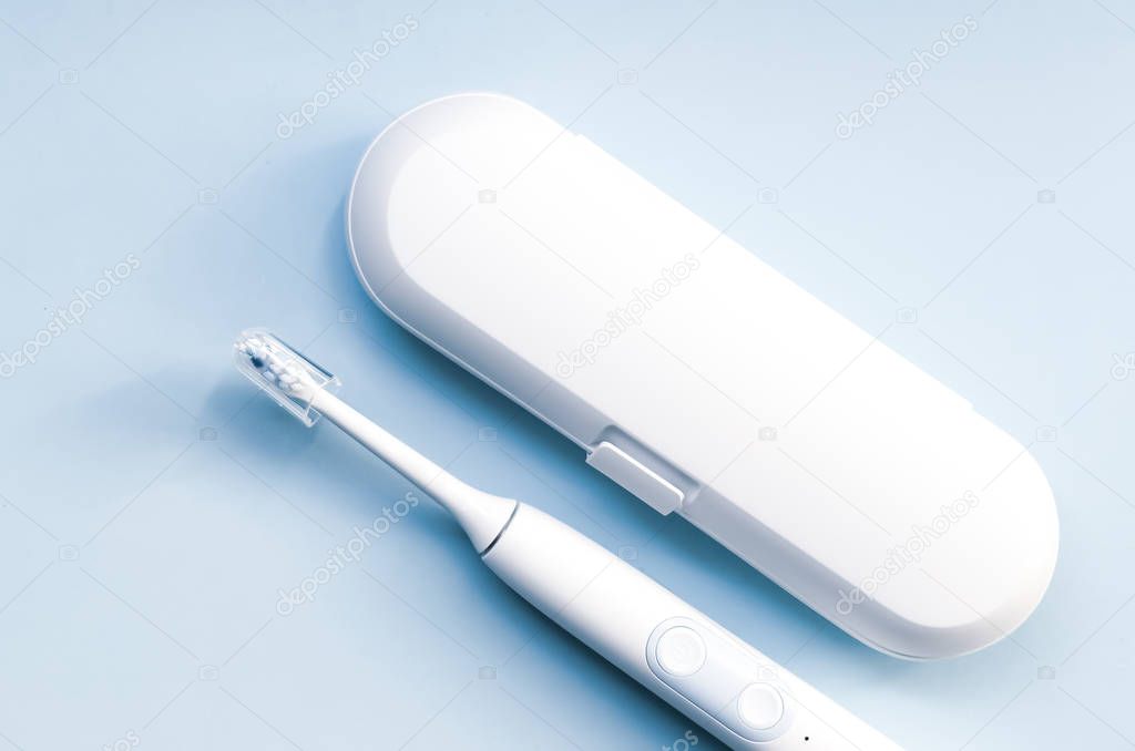 Electric toothbrush on blue background.