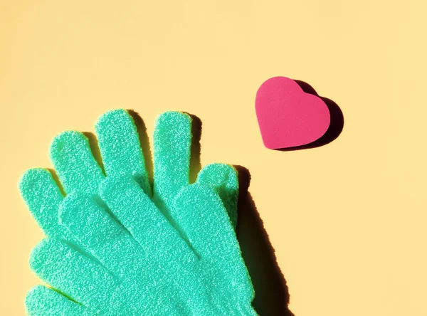 Green gloves and heart sponge. — Stock Photo, Image