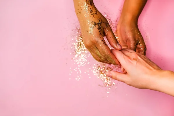 Hands and golden glitters.