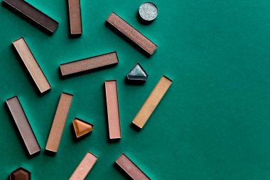 Göz farı, makyaj seti. Profesyonel çok renkli göz farı paleti. Koyu yeşil arka planda profesyonel çok renkli makyaj.