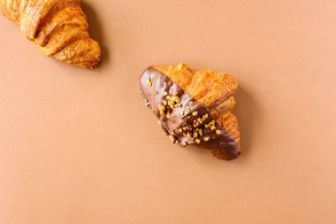 Kahverengi arka planda klasik ve koyu çikolatalı kruvasanlar. Tatlı yemek tasarımı. 