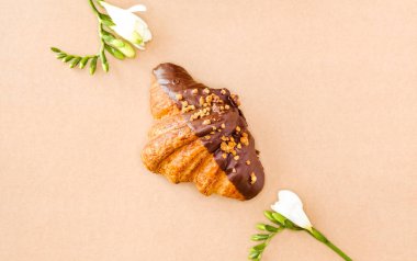 Kahverengi arka planda klasik ve koyu çikolatalı kruvasanlar. Tatlı yemek tasarımı. 