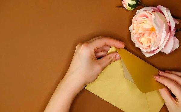 Golden Envelope Artificial Pink Rose Woman Hand Brown Background Golden — Stock Photo, Image