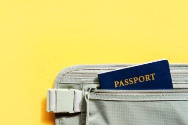 Seyahat konsepti. Pasaport ve düzenleyici kemer cüzdanı sarı arka planda duruyordu..