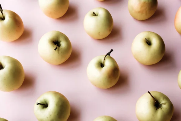 Monochrome apples pattern on pastel background.