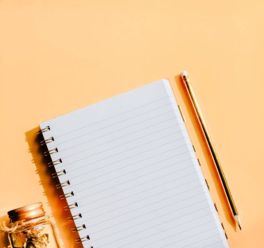 Not defteri, altın kalem ve pastel turuncu arka planda ataç. Okul konseptine dönelim.. 