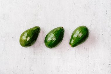 Gri arka planda yeşil avokado, üst manzara, sağlıklı gıda konsepti..