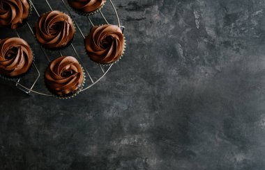 Koyu çikolatalı kekler ve koyu arkaplanda kakao parçaları. Tatlı yemek konsepti. 