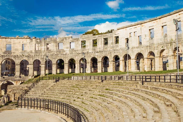 Monumental ancient Roman arena in Pula, Istria, Croatia, interior of historic amphitheater, wide angle view of high walls on blue sky background