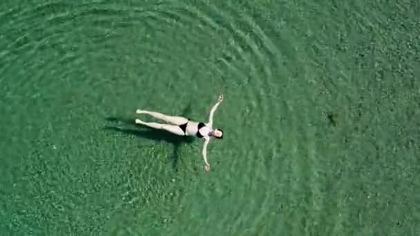 Femme profitant de vacances, flottant en bikini à la surface de la mer dans l'eau cristalline, jeune fille insouciante sur la mer, relaxant, Dugi otok île, Croatie