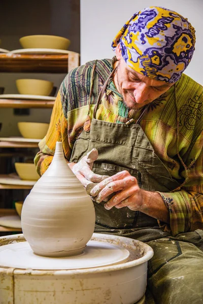 Potter working on potter\'s wheel with raw clay with hands, making new amphora bowl, small art business concept