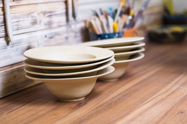 El yapımı tabaklar, çanak çömlek stüdyosundaki aletler, sığ alan borcu, küçük sanat işi konsepti.