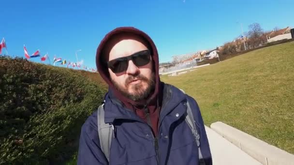 ジャケットとサングラスでクールな髭の男は 市内の階段を歩いて アクションカメラ 広角ビュー コンセプトに影響を与えるソーシャルメディアでVlogging — ストック動画