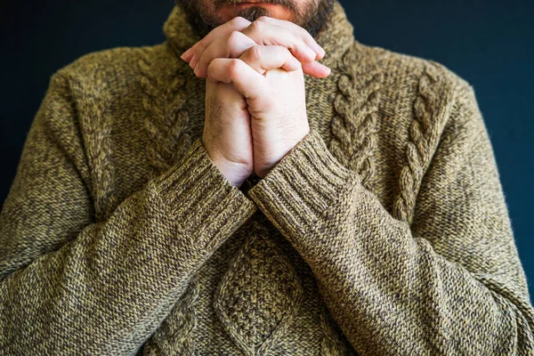 Unhappy depressed worried man in sweater, head resting on crossed arms, half face