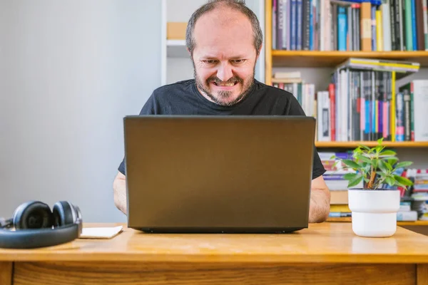 Man working from home office made a mistake, face expression. Bearded man sitting behind vintage desk at home made something wrong and having business problem