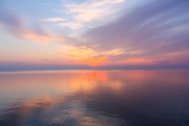 Günbatımı gökyüzü ile ilham verici sakin deniz. Meditasyon okyanusu ve gökyüzü arka planı. Suyun üzerinde renkli bir ufuk.