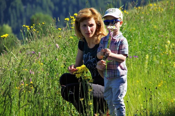 Жінка з дитиною, що збирає квіти — стокове фото