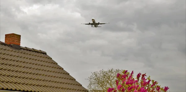 Aereo passeggeri che sorvola edifici residenziali — Foto Stock