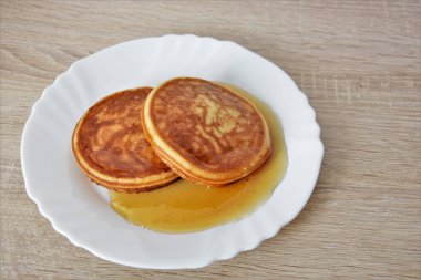 iki sıvı bal ile doldurulmuş krep yalan beyaz bir plaka üzerinde