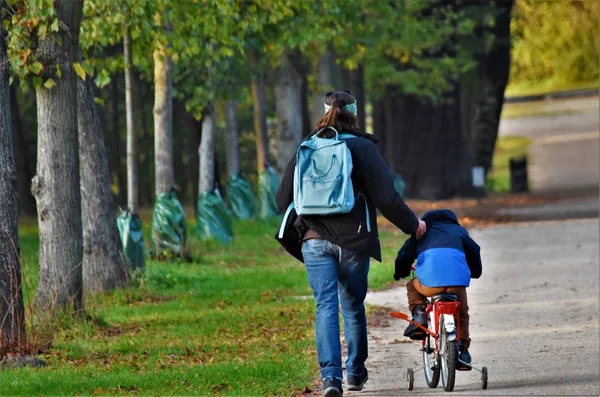 Niño Monta Una Bicicleta Junto Una Mujer Que Camina — Foto de Stock