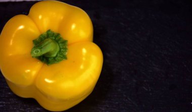 Siyah arka planda taze sarı biber.