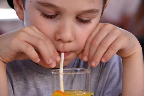 Junge Trinkt Saft Durch Einen Strohorangensaft — Stockfoto