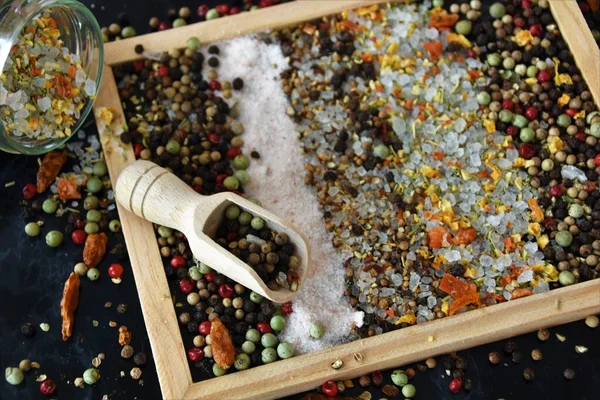 dry seasoning, peppercorns and salt on a black board