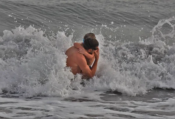Mladý Muž Dítětem Náručí Stojí Bouřlivém Moři — Stock fotografie