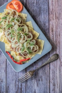 Besthe, ulusal bir Tatar yemeğidir. Haşlanmış et ve soğanlı kare makarna. Siyah bir arkaplanda