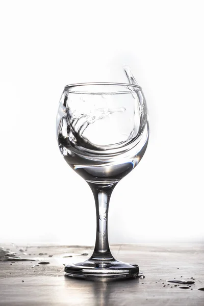 Salpicadura de agua de un vaso sobre un fondo blanco — Foto de Stock