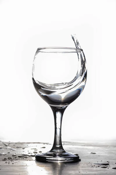 Vatten stänk från ett glas på en vit bakgrund — Stockfoto