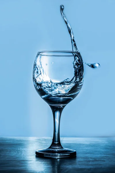 Glass of martini splash on a blue background — Stock Photo, Image