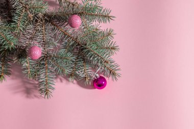 Pembe arka planda mavi ladin ve Noel oyuncakları
