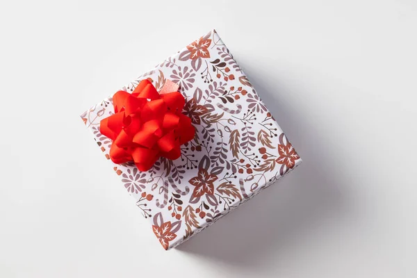 Kırmızı fiyonklu hediye kutusu yeşil arka planda, bayram için. Boşluğu kopyala — Stok fotoğraf