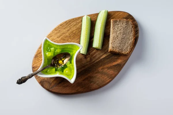 Engarrafamento de pepino em um boliche, em uma tábua de madeira e fundo branco — Fotografia de Stock