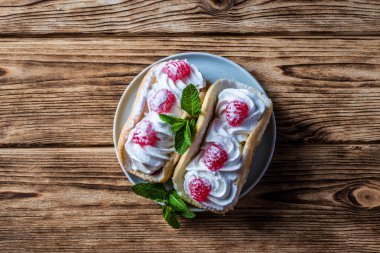 Ahşap zemin üzerinde ahududu ve çikolata parçacıkları olan pasta.