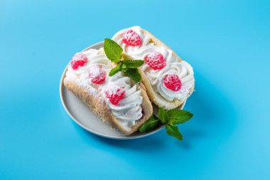 Mavi arka planda ahududu ve çikolata parçacıklı kek.